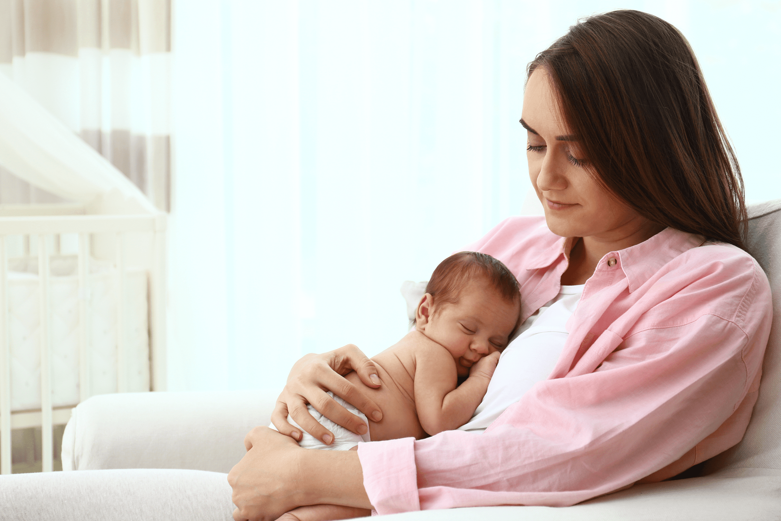 Mamá durmiendo a su bebé en brazos