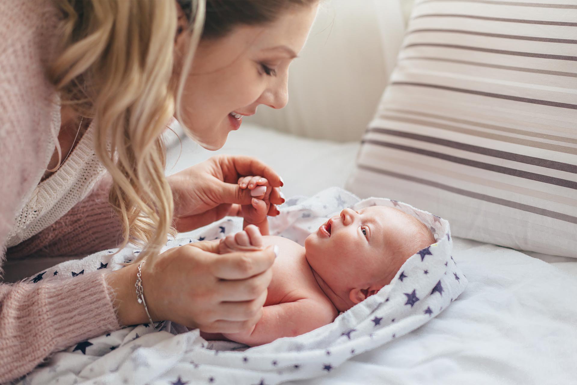 Mamá jugando con su bebé en la cama