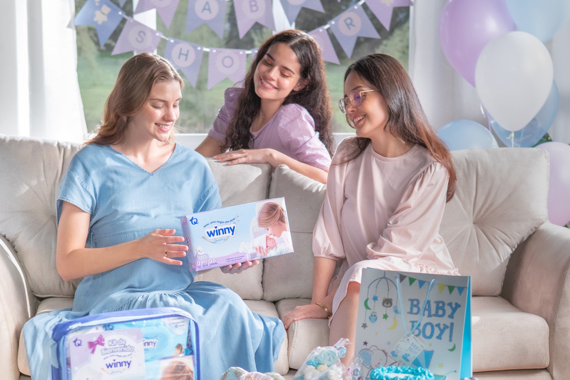 Mujer embarazada con amigas a su alrededor y productos Winny