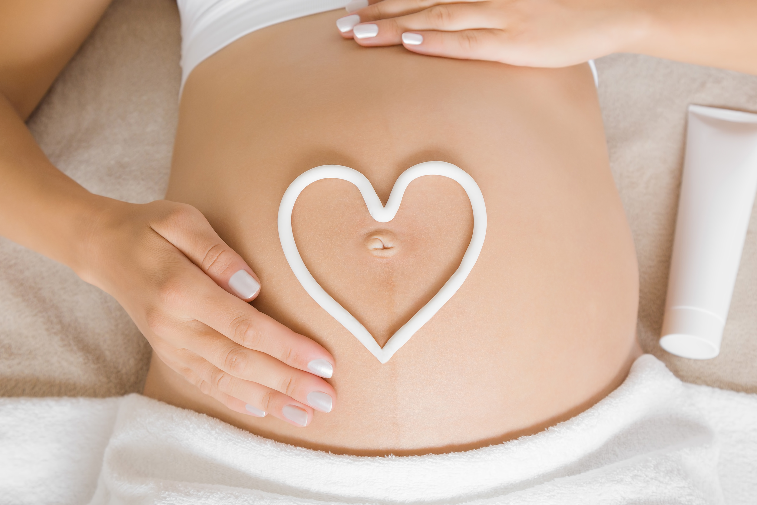 Corazón de crema en barriga de embarazada