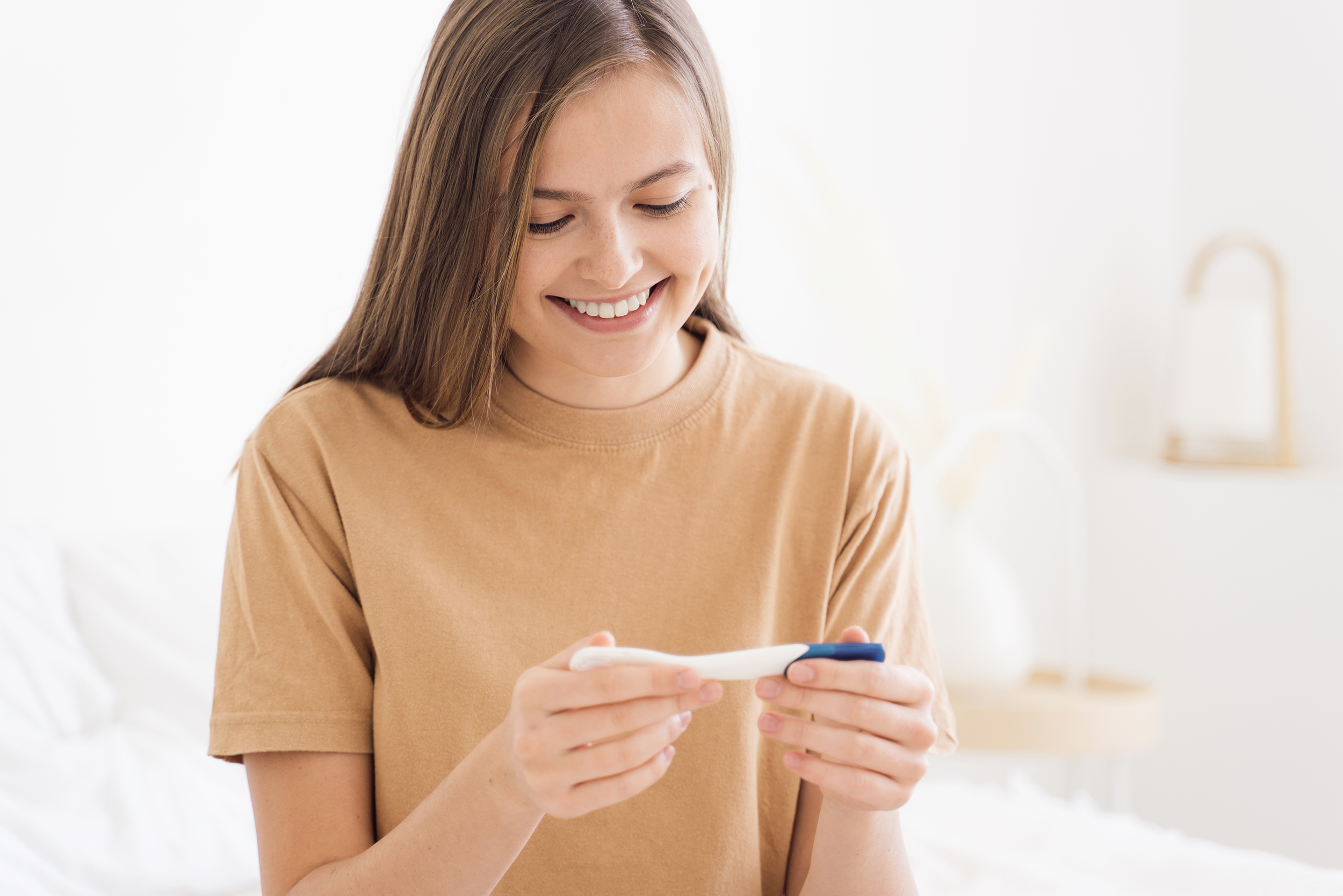 Mujer viendo su prueba de embarazo positiva