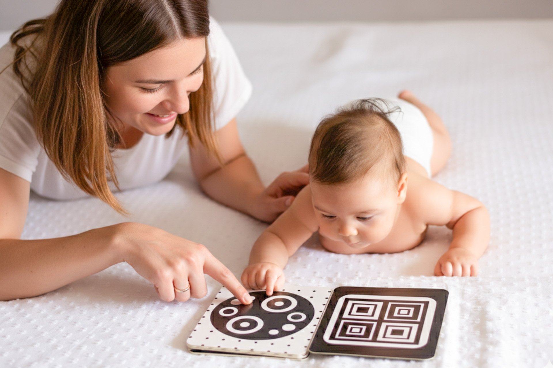 Mamá mostrando libro a su bebé.
