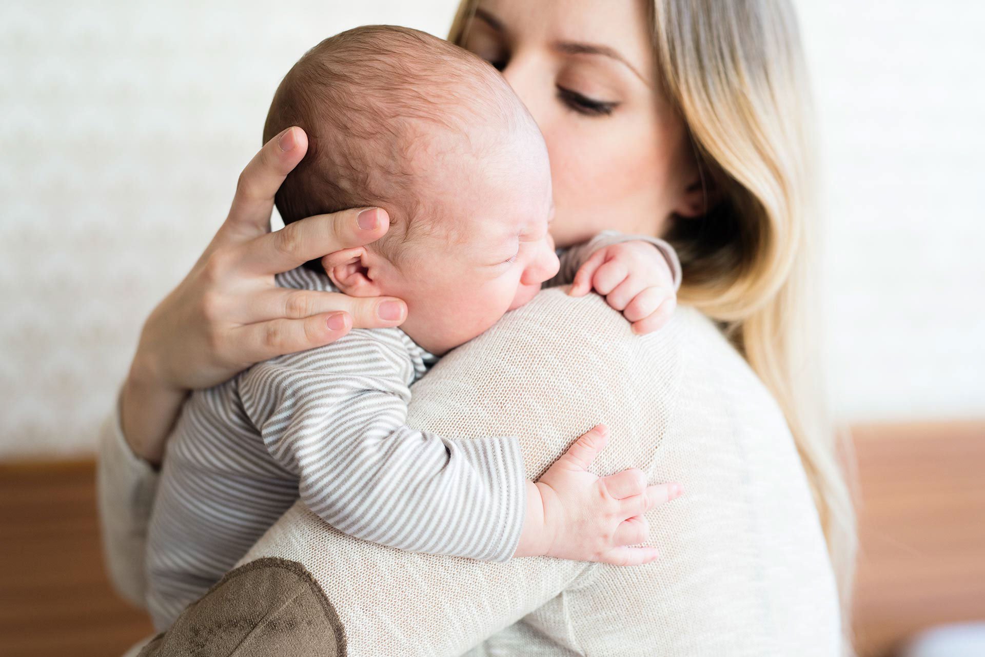 Mamá dándole un beso a su bebé en la cabeza