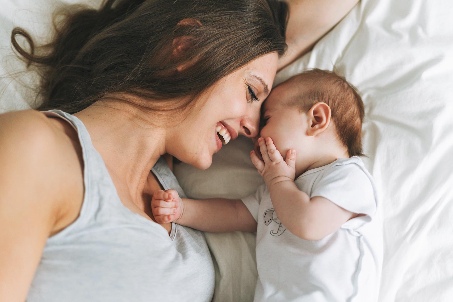 Mamá acostada con su bebé recién nacido