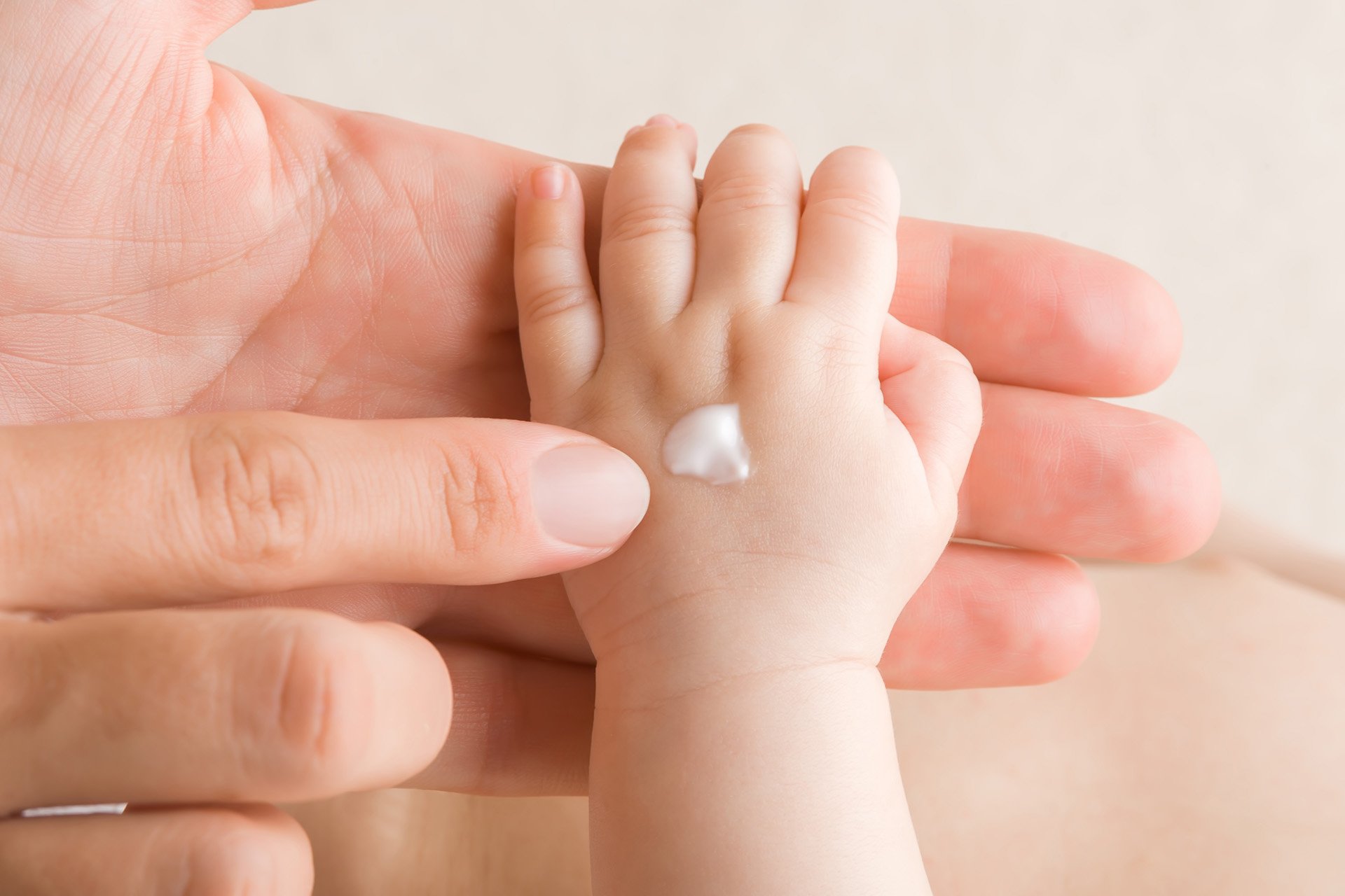 Mano de bebé con crema.