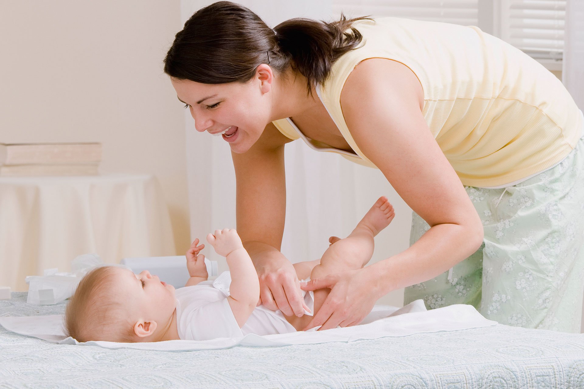 Mamá cambiando el pañal de su bebé.