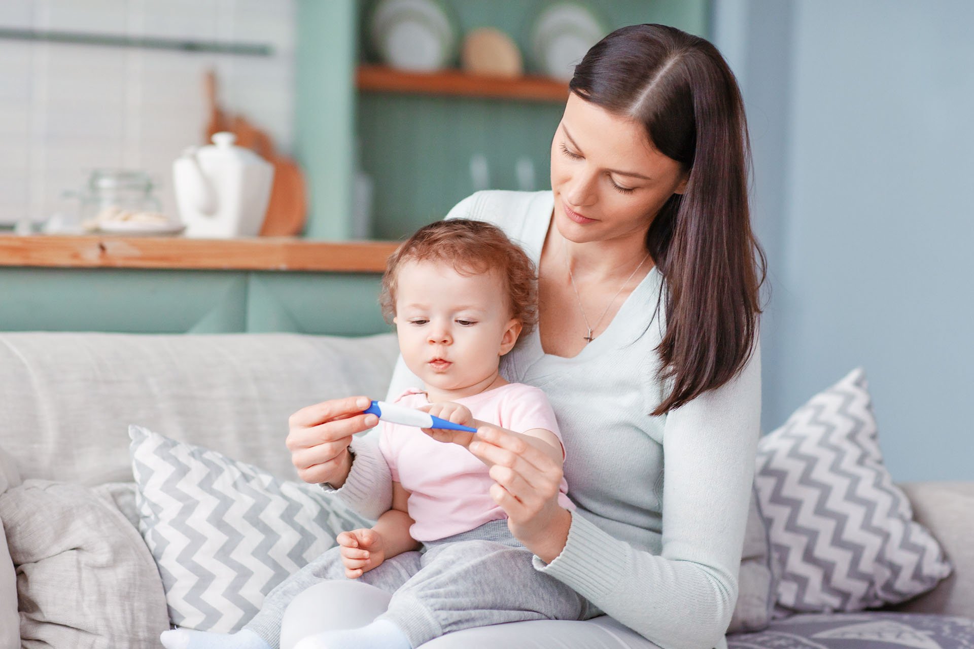 Mamá tomando la temperatura de su bebé.